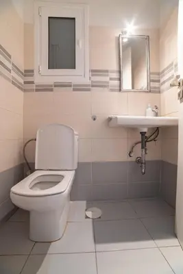 a bathroom with a toilet and a sink at Spacious Apartment Downtown Glyfada in Athens