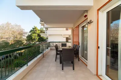 a balcony with a table and chairs on it at Spacious Apartment Downtown Glyfada in Athens