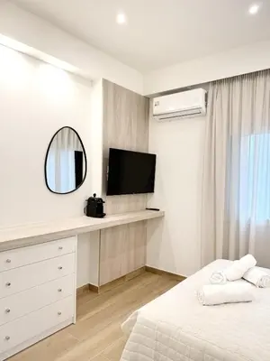 a white bedroom with a bed and a mirror at Urban Pad Athens in Athens