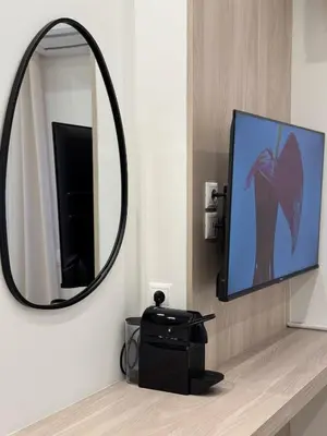 a bathroom with a mirror and a tv on a counter at Urban Pad Athens in Athens