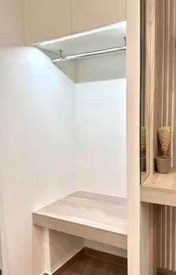 a walk in closet with white walls and a bench at Urban Pad Athens in Athens