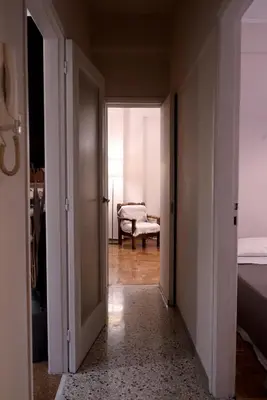 an open door to a bedroom with a bed and a chair at Koukaki Athens 2 bedrooms flat next to Acropolis in Athens