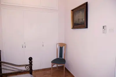 a room with a chair and a picture on the wall at Koukaki Athens 2 bedrooms flat next to Acropolis in Athens