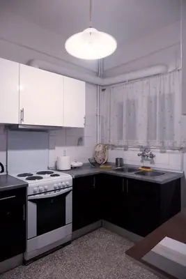 a kitchen with white cabinets and a stove top oven at Koukaki Athens 2 bedrooms flat next to Acropolis in Athens