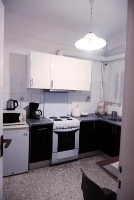 a kitchen with white cabinets and a stove top oven at Koukaki Athens 2 bedrooms flat next to Acropolis in Athens