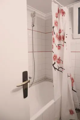 a shower curtain with pink flowers on it in a bathroom at Koukaki Athens 2 bedrooms flat next to Acropolis in Athens