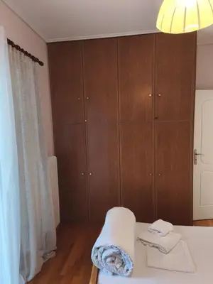 a bedroom with a bed and wooden cabinets at Acropolis Sweet House 6 in Athens