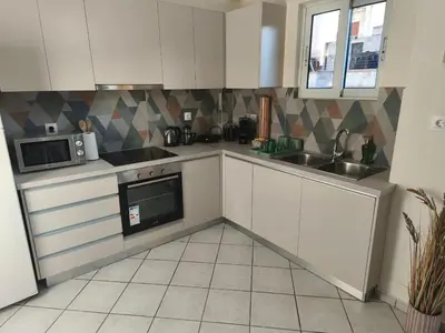 a kitchen with white cabinets and a sink and a microwave at Acropolis Sweet House 6 in Athens