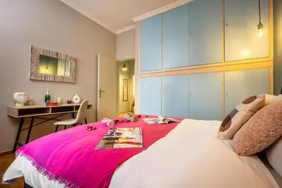 a bedroom with a large bed with a pink blanket at Magic Moments Near The Acropolis in Athens