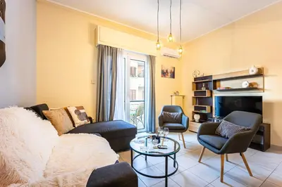 a living room with a couch and chairs and a tv at Magic Moments Near The Acropolis in Athens