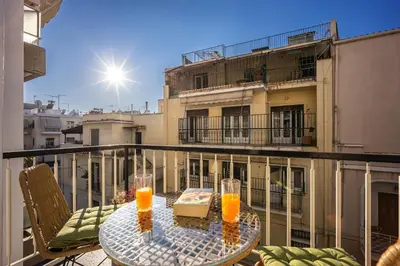 a balcony with a table and two glasses of orange juice at Magic Moments Near The Acropolis in Athens