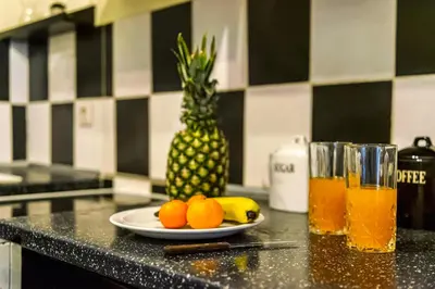 a plate of fruit on a counter next to a pineapple at Magic Moments Near The Acropolis in Athens