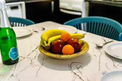 a bowl of fruit on a table next to a bottle at Magic Moments Near The Acropolis in Athens