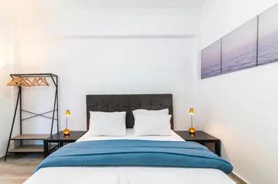 a bedroom with a bed and two tables with lamps at Stylish New Modern Residence - 270m to Metro - Central Athens in Athens