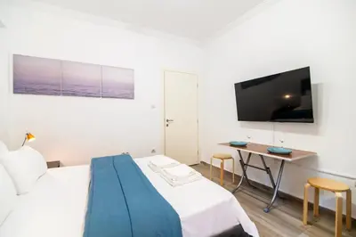 a bedroom with a bed and a desk and a tv at Stylish New Modern Residence - 270m to Metro - Central Athens in Athens