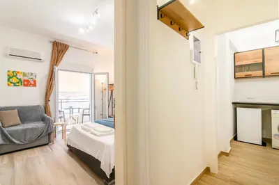 a bedroom and a living room with a bed and a chair at Stylish New Modern Residence - 270m to Metro - Central Athens in Athens