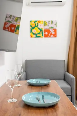 a wooden table with two plates and a glass at Stylish New Modern Residence - 270m to Metro - Central Athens in Athens