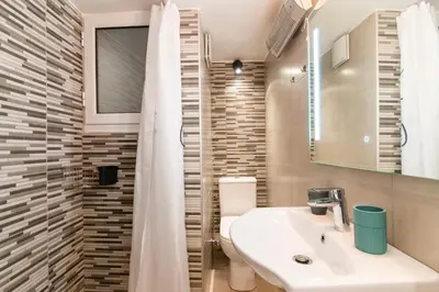 a bathroom with a sink and a mirror and a shower at Stylish New Modern Residence - 270m to Metro - Central Athens in Athens