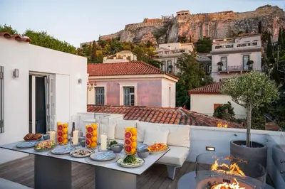 a table with food on top of a balcony with mountains at Plaka Villa with Epic Acropolis Views in Athens