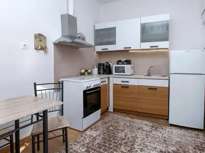 a kitchen with white appliances and a wooden table at Green Dome Escape in Athens