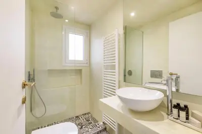 a white bathroom with a sink and a shower at Elevated 2BR Apartment in Chalandri by UPSTREET in Athens