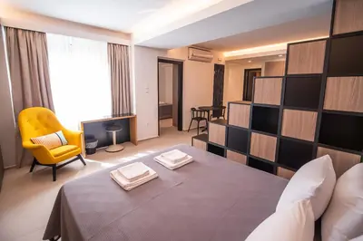 a hotel room with a bed and a yellow chair at Millennial Apartments Athens in Athens