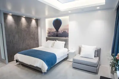 a bedroom with a bed and a chair and a balloon at Millennial Apartments Athens in Athens