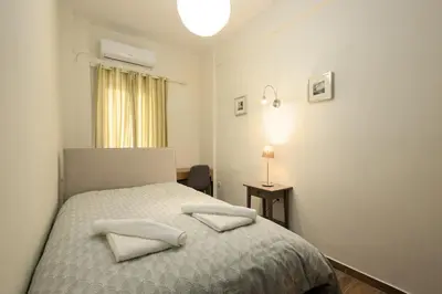 a bedroom with a bed with two pillows on it at Sunny Athenian Apartment in Athens