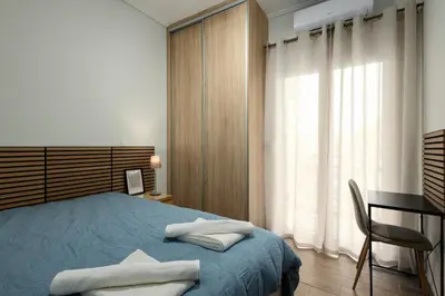 a bedroom with a bed and a desk and a window at Sunny Athenian Apartment in Athens