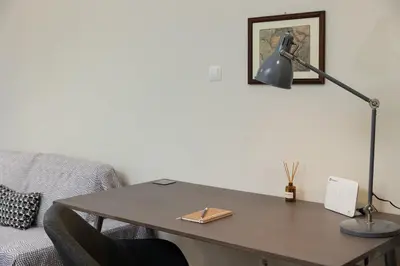 a desk with a lamp and a table with a couch at Sunny Athenian Apartment in Athens