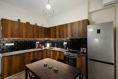 a kitchen with a table and a refrigerator at Sunny Athenian Apartment in Athens