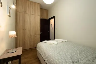 a bedroom with a bed and a table and a lamp at Sunny Athenian Apartment in Athens