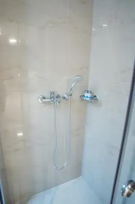 a shower with a shower head in a bathroom at Millennial Apartments Voulis in Athens