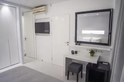 a white bathroom with a sink and a mirror at Millennial Apartments Voulis in Athens
