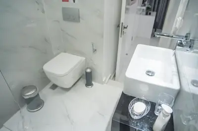 a white bathroom with a toilet and a sink at Millennial Apartments Voulis in Athens
