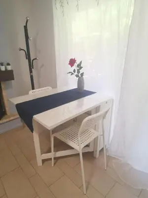 a table and a chair with a flower in a vase at Andy's sweet house in Athens