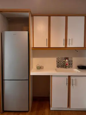 a kitchen with white cabinets and a refrigerator at Βένερε in Athens