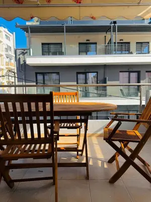 a table and two chairs on a balcony with a building at Βένερε in Athens