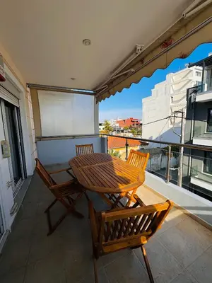 a wooden table and two chairs on a balcony at Βένερε in Athens