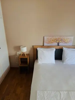 a bedroom with a bed with white sheets and a lamp at Βένερε in Athens