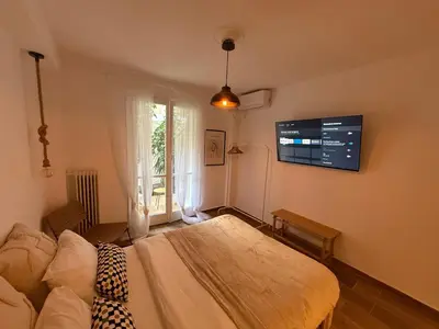 a bedroom with a bed and a tv on the wall at Athens Homey Haven in Athens