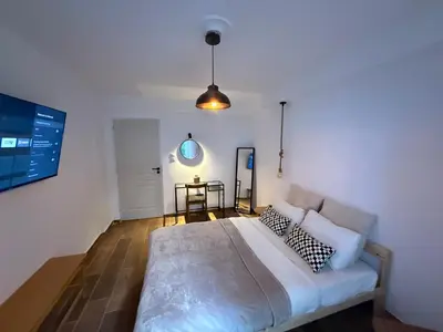 a bedroom with a large white bed and a table at Athens Homey Haven in Athens