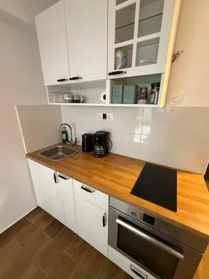 a kitchen with white cabinets and a sink at Athens Homey Haven in Athens