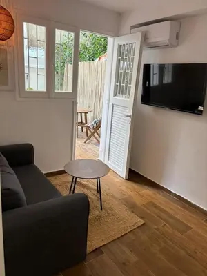 a living room with a couch and a table and a tv at Athens Homey Haven in Athens