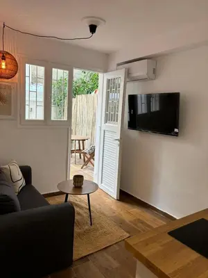 a living room with a couch and a tv on a wall at Athens Homey Haven in Athens