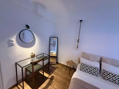 a living room with a couch and a table and a mirror at Athens Homey Haven in Athens