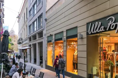 people walking in front of a milka store on a city street at ABOV Acropolis in Athens