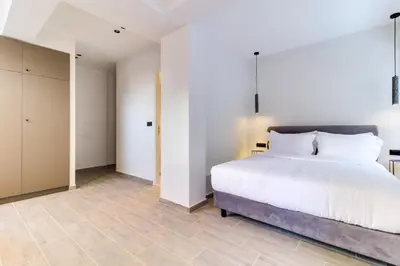 a bedroom with a white bed and a tiled floor at ABOV Acropolis in Athens