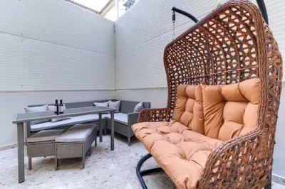 a wicker bench in a room with a table at ABOV Athens in Athens