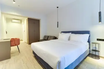 a bedroom with a large white bed and a chair at ABOV Athens in Athens
